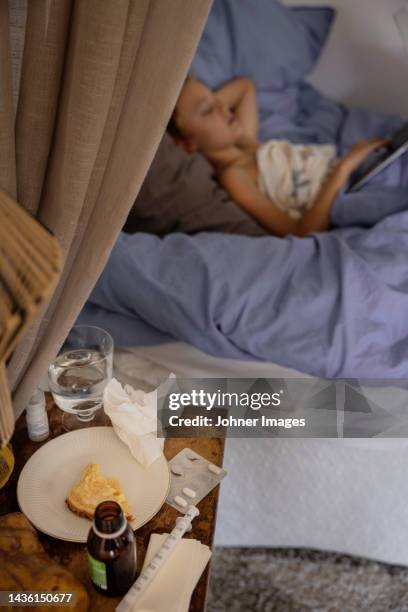 sick boy lying in bed - bedside table kid asleep stock pictures, royalty-free photos & images