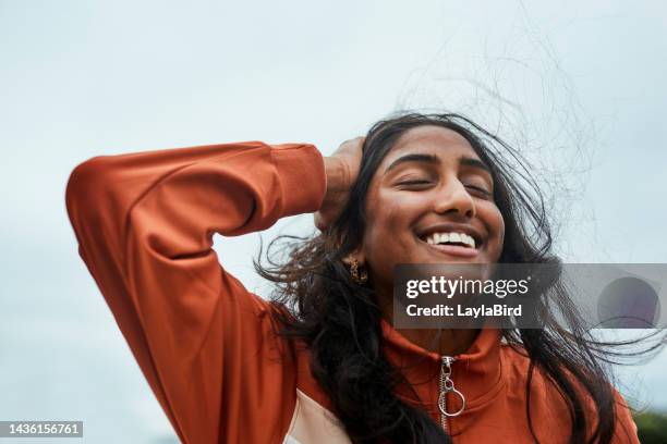 girl, happy and hand in hair on vacation, holiday or trip to enjoy freedom outdoors in winter. woman, smile and hands on head with happiness to relax with carefree, joy and free expression on face - hand on head stockfoto's en -beelden