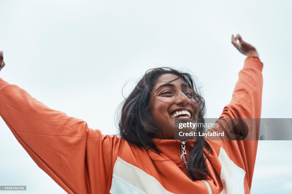 Liberté, forme physique et femme gagnante célébrant l’objectif de santé après l’exercice dans la nature, heureuse et excitée. Motivation, bien-être et succès avec une fille indienne qui encourage la victoire, exprime sa joie à l’entraînemen