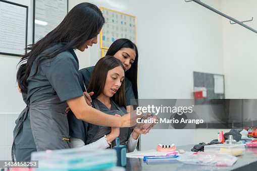 Dentistry student performs her exercises in class while working with ceramic teeth Dentistry student performs her exercises in class while working with ceramic teeth