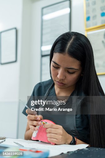Dentistry student performs her exercises in class while working with ceramic teeth Dentistry student performs her exercises in class while working with ceramic teeth