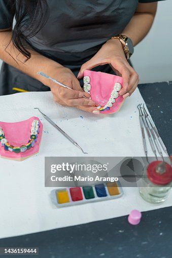 Dentistry student performs her exercises in class while working with ceramic teeth Dentistry student performs her exercises in class while working with ceramic teeth