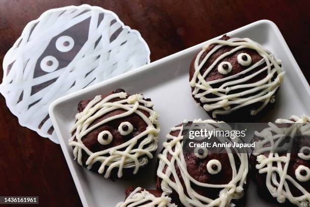 halloween mummy cookies on white plate - annie sprinkle stock pictures, royalty-free photos & images