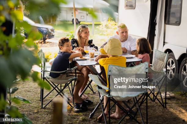 family sitting at picnic table - family caravan stock pictures, royalty-free photos & images