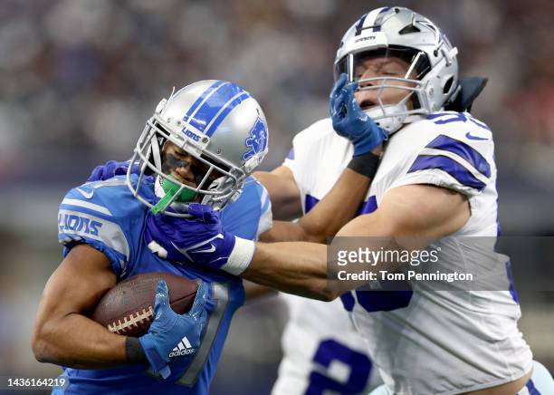 Kalif Raymond of the Detroit Lions runs with the ball as he stiff arms Leighton Vander Esch of the Dallas Cowboys during the first quarter AT&T...