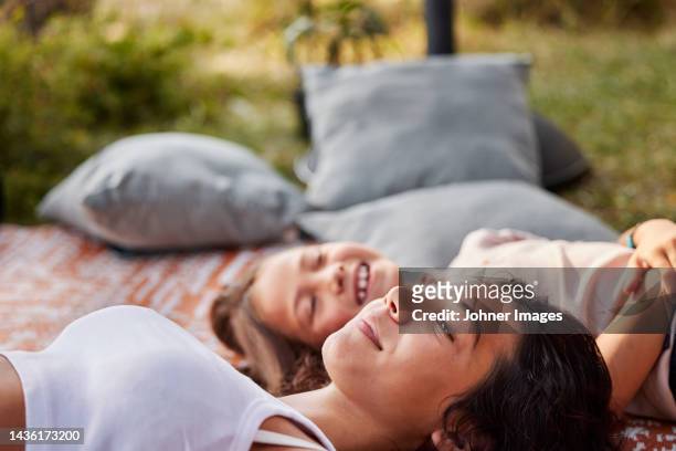 girls lying down on blanket - girl lying down stock pictures, royalty-free photos & images