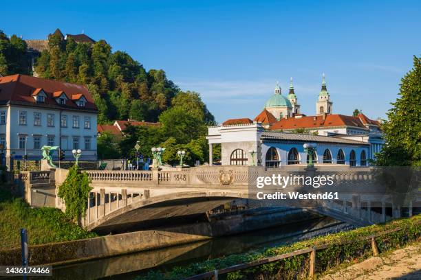 slovenia, ljubljana, dragon bridge stretching over ljubljanica river - ljubljana slovenia stock pictures, royalty-free photos & images