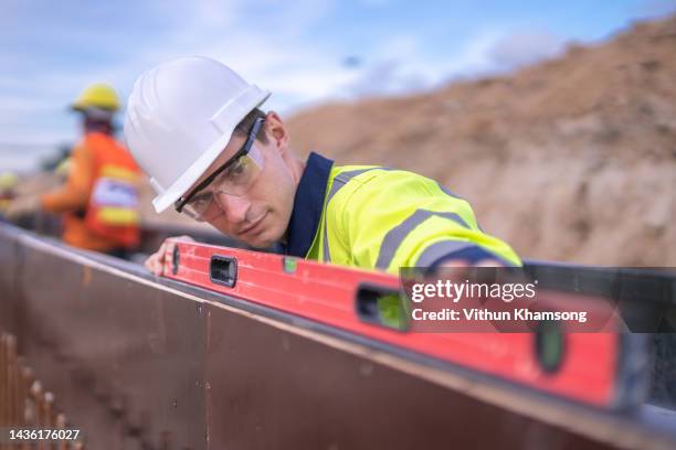 male engineer check elevation and quality work at construction site - waterpas stockfoto's en -beelden