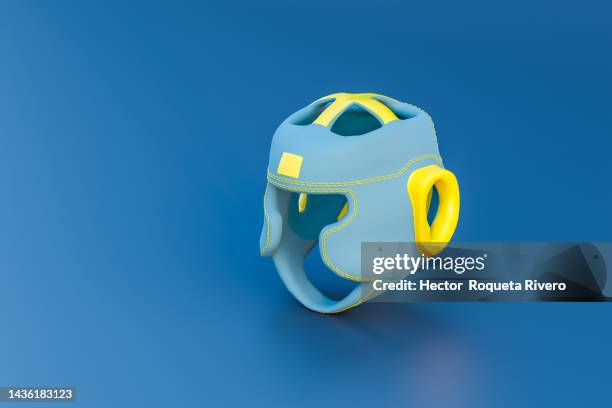 3d render of blue and yellow boxing helmet on blue background, sport concept - head protector stock pictures, royalty-free photos & images