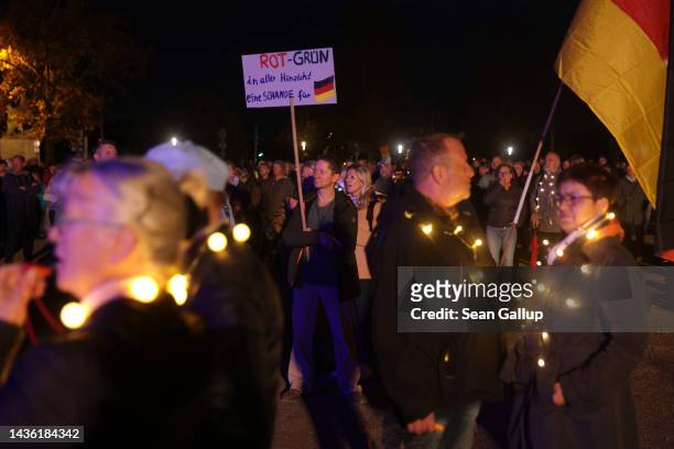Man holds a sign that reads: "Red-Green a disgrace for Germany in every way!" prior to a Monday-night "stroll" of protesters on October 24, 2022 in...
