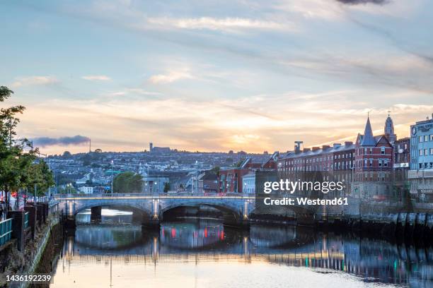 ireland, munster, cork, view of st. patrick's bridge stretching over river lee at sunset - river lee cork stock pictures, royalty-free photos & images