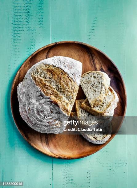 sliced bread on wooden plate on green background - sliced bread stock pictures, royalty-free photos & images