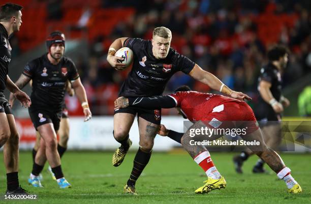 Dan Fleming of Wales is tackled by Addin Fonua-Blake of Tonga during the Rugby League World Cup 2021 Pool D match between Tonga and Wales at Totally...