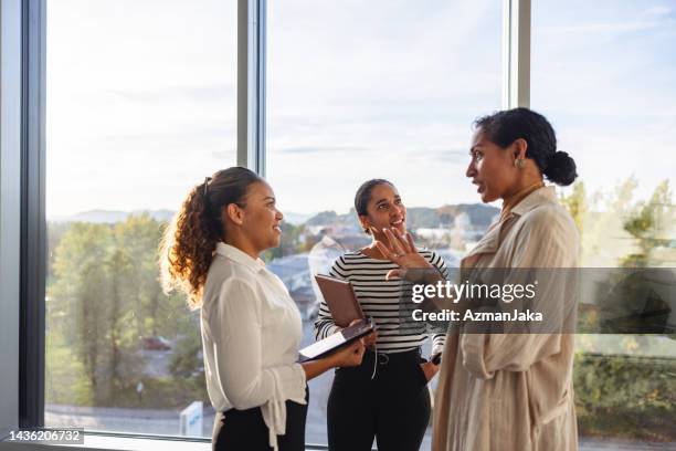 lächelnde gruppe von weiblichen geschäftsleuten, die während einer kurzen pause reden und lachen - spirituosen stock-fotos und bilder