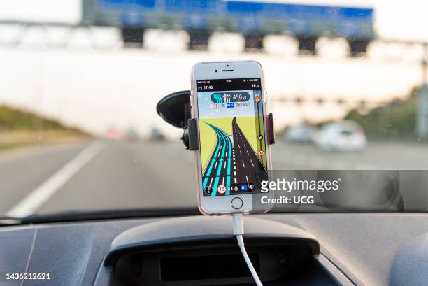 Using satnav app on a mobile phone while driving on M25 motorway, UK.