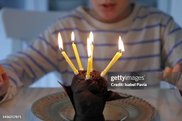 boy blowing out candles on birthday cupcake - boys birthday stock pictures, royalty-free photos & images