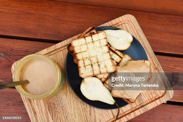 peanut butter with croutons on a wooden board. snack. american cuisine. - untar de mantequilla fotografías e imágenes de stock