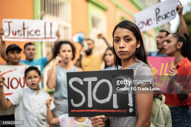 portrait of young protestor woman holding a sign at the protest - resistance to change stock pictures, royalty-free photos & images