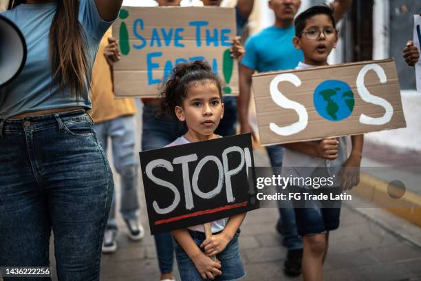 children holding signs about the environment at a protest - environmental protest stock pictures, royalty-free photos & images