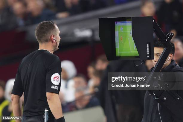 Match Referee, David Coote checks the VAR monitor before awarding a penalty to West Ham United during the Premier League match between West Ham...