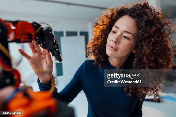 engineer examining robotic arm in office - robotic arm 個照片及圖片檔