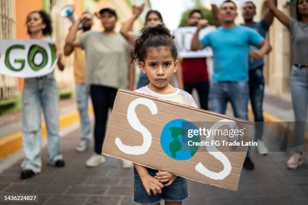 portrait of child girl holding a sign about the environment on the protest - climate change children stock pictures, royalty-free photos & images