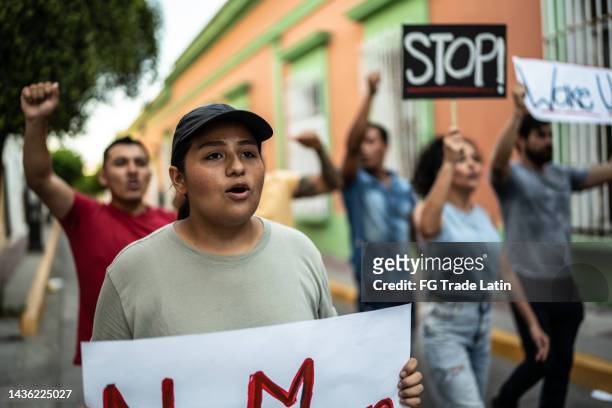 young woman holding signs during on a demonstration outdoors - defend your rights stock pictures, royalty-free photos & images