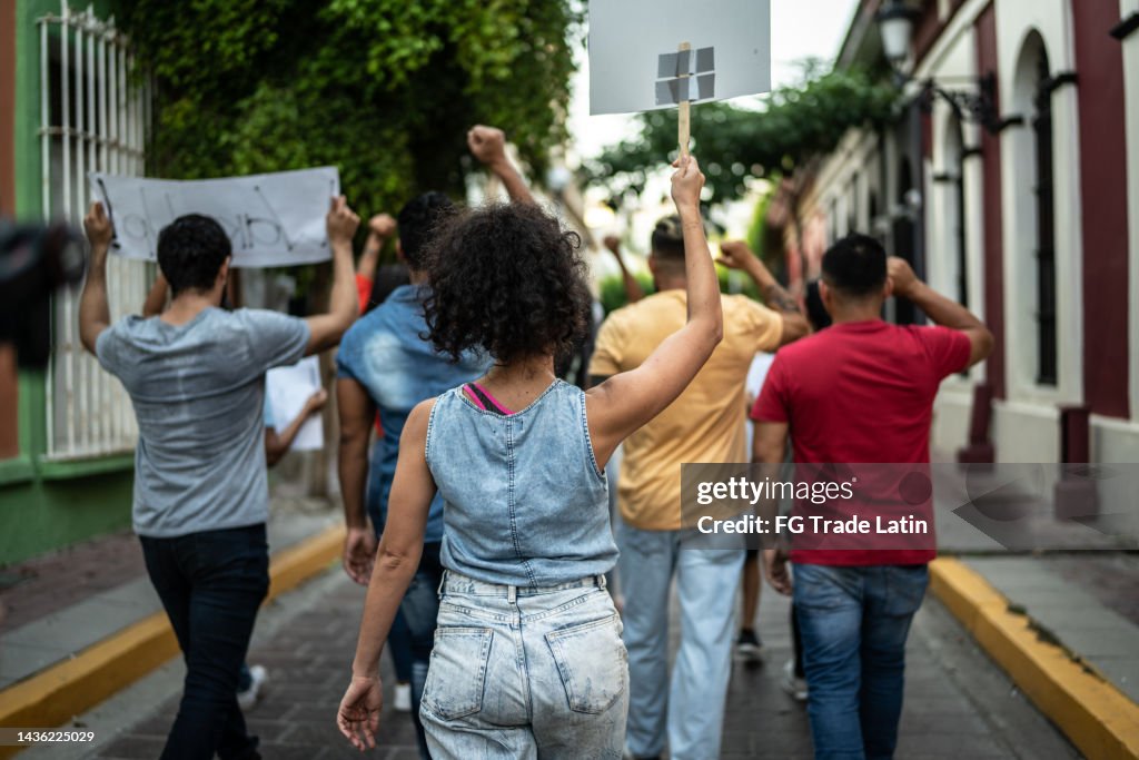 Protesters walking while holding signs during on a demonstration outdoors