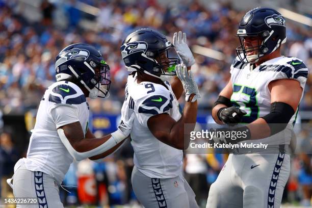 Kenneth Walker III of the Seattle Seahawks celebrates his touchdown with teammates Dee Eskridge and Austin Blythe during the first quarter against...