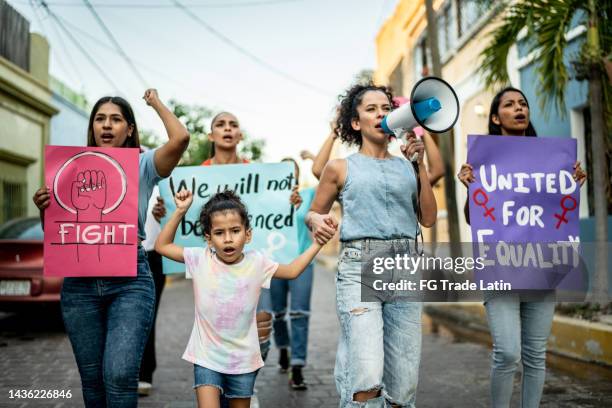 mid adult woman leading a demonstration using a megaphone outdoors - gender equality stock pictures, royalty-free photos & images