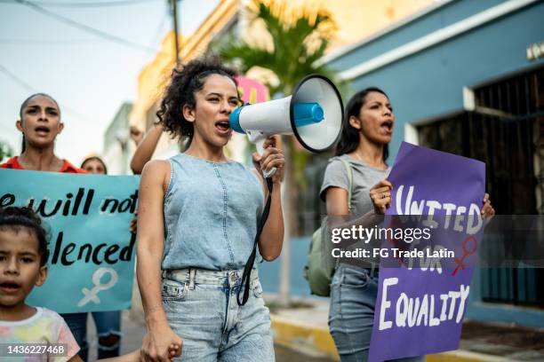 mujer mediana adulta liderando una demostración usando un megáfono al aire libre - equidad de genero fotografías e imágenes de stock