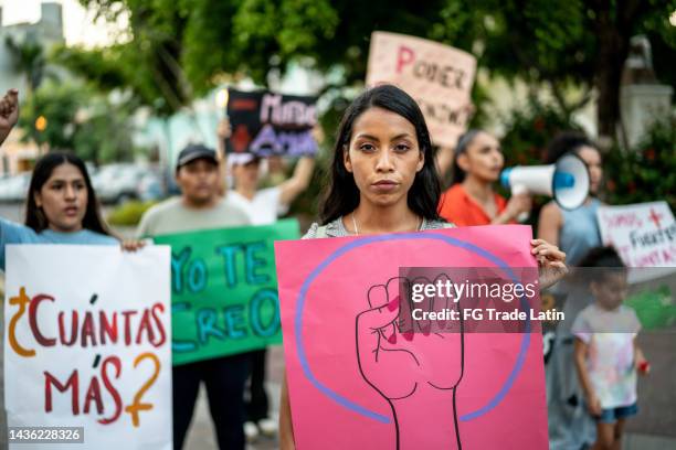 portrait of young woman holding a sign on a protest - women's rights stock pictures, royalty-free photos & images
