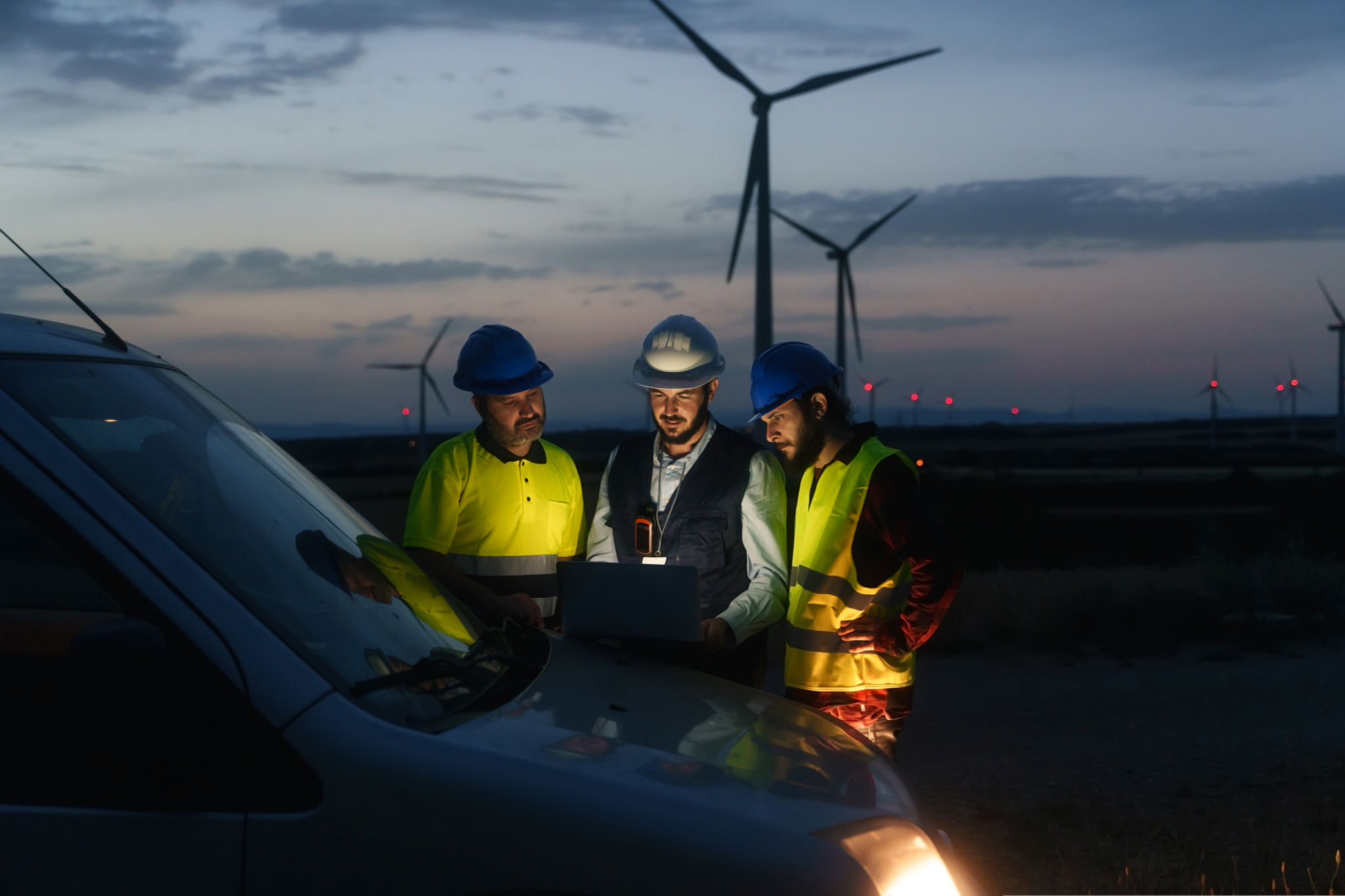 Technicians engineers working in wind turbine electricity plant at night. Renewable energy solution for climate change Technicians engineers working in wind turbine electricity plant at night. Renewable energy solution for climate change
