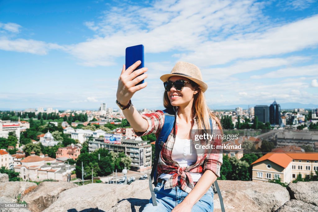 Touristin mit Rucksack beim Selfie. Speicherplatz kopieren