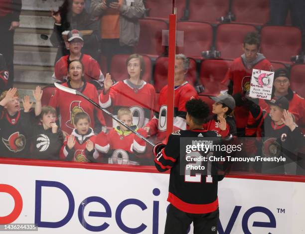 Mathieu Joseph of the Ottawa Senators tosses a puck to a fan during warm-up prior to a game against the Dallas Stars at Canadian Tire Centre on...