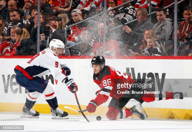 Jack Hughes of the New Jersey Devils and Dmitry Orlov of the Washington Capitals battle for the puck during the first period at the Prudential Center...