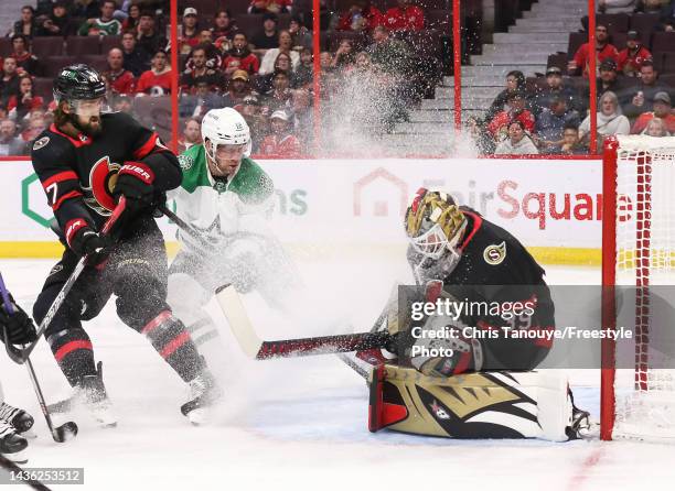 Magnus Hellberg of the Ottawa Senators makes a save as Radek Faksa of the Dallas Stars sprays ice at Hellberg as Mark Kastelic of the Ottawa Senators...