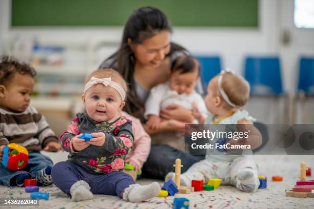 childcare worker with babies - daycare stock pictures, royalty-free photos & images