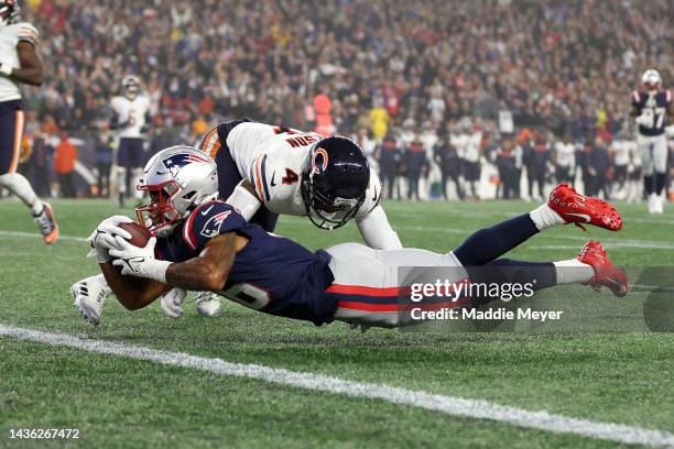 Jakobi Meyers of the New England Patriots dives across the goal line to score a 30-yard receiving touchdown as Eddie Jackson of the Chicago Bears is...