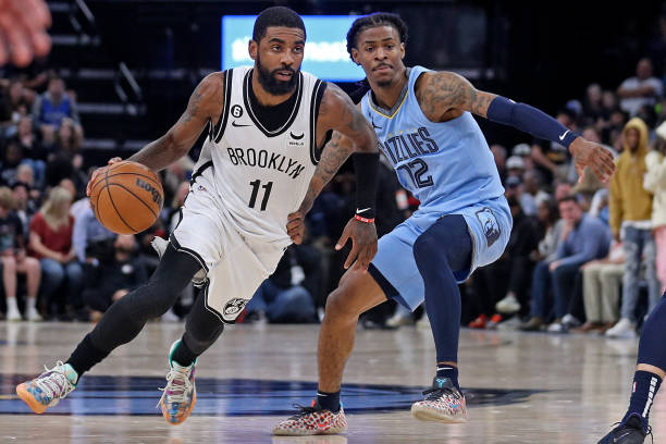 Kyrie Irving of the Brooklyn Nets goes to the basket against Ja Morant of the Memphis Grizzlies during the game at FedExForum on October 24, 2022 in...