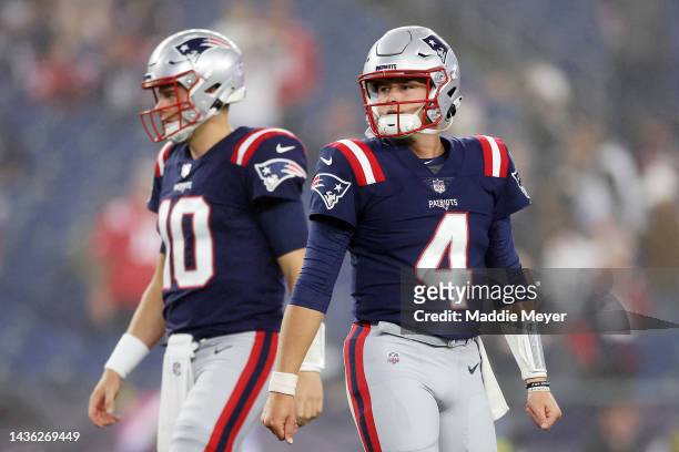 Mac Jones and Bailey Zappe of the New England Patriots stand on the field prior to the game against the Chicago Bears at Gillette Stadium on October...