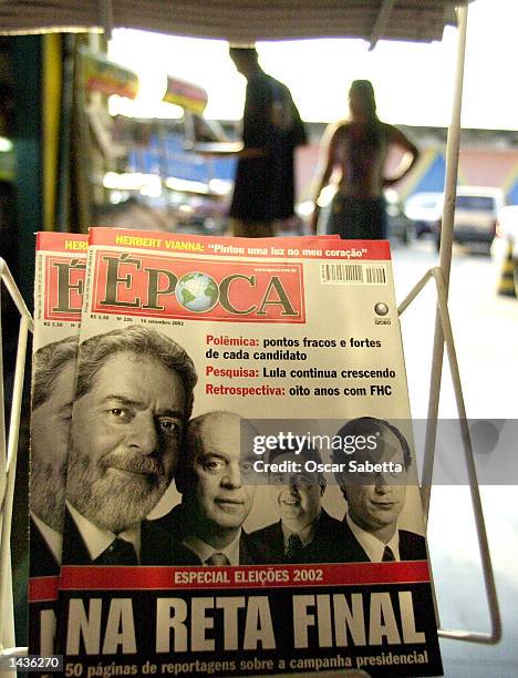 Pedestrians walks past a newspapers stand displaying magazines showing Brazilian presidential candidates Luiz Inacio Lula da Silva, Jose Serra,...