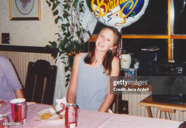 1990s teenager birthday party, 2000s style, vintage birthday party family photo candid teen smiling with braces on teeth - 90s teens stock-fotos und bilder