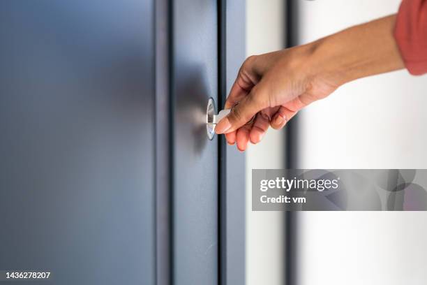 woman's hand using key to unlock doors - turning key stock pictures, royalty-free photos & images