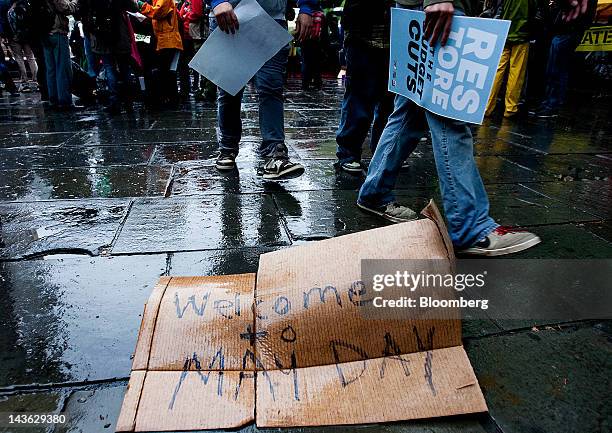 Wet sign reads "Welcome to May Day" near demonstrators affiliated with the Occupy Wall Street movement in New York, U.S., on Tuesday, May 1, 2012....