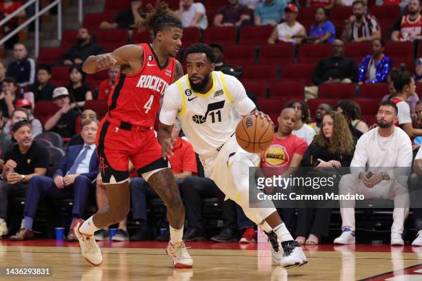 Mike Conley of the Utah Jazz drives against Jalen Green of the Houston Rockets during the first half at Toyota Center on October 24, 2022 in Houston,...