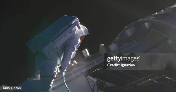 an astronaut in a white spacesuit at the spacecraft in outer space - cosmonaut imagens e fotografias de stock