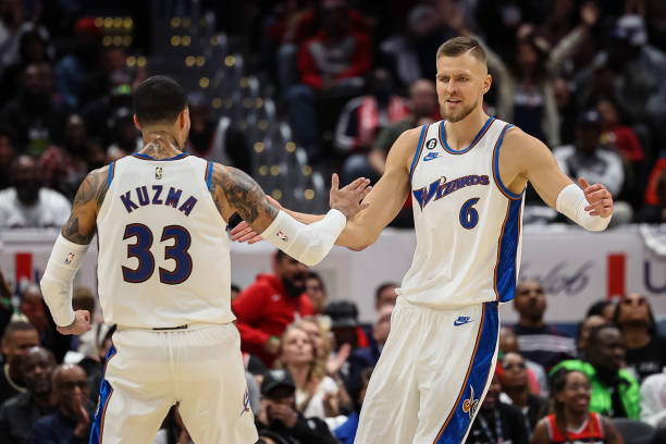 Kristaps Porzingis of the Washington Wizards celebrates with Kyle Kuzma after a play against the Chicago Bulls during the first half at Capital One...