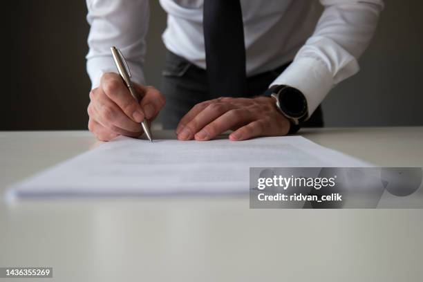 signing official document - menselijk lichaamsdeel stockfoto's en -beelden