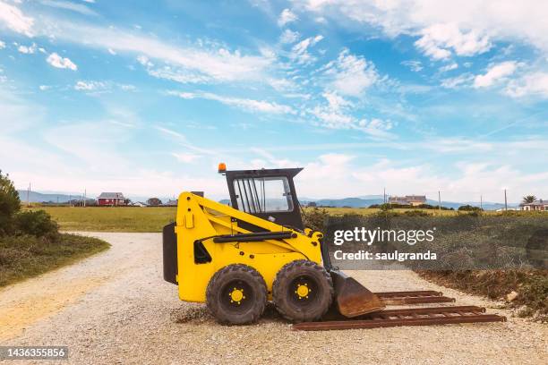 little yellow excavator parked outdoors - pá escavadora imagens e fotografias de stock